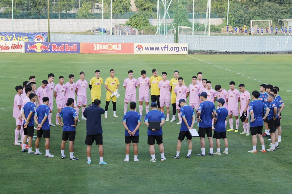 HLV Kim Sang-sik trao đổi cùng các cầu thủ trước buổi tập. Ảnh: MINH HOÀNG