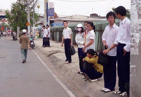 Đội nắng mưa chờ xe buýt