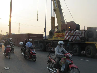 Quay đầu gấp, thùng hàng 40 feet văng xuống đường