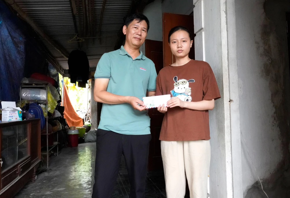 Đại diện Báo SGGP trao tiền hỗ trợ cho em Hoàng Thị Hải Yến
