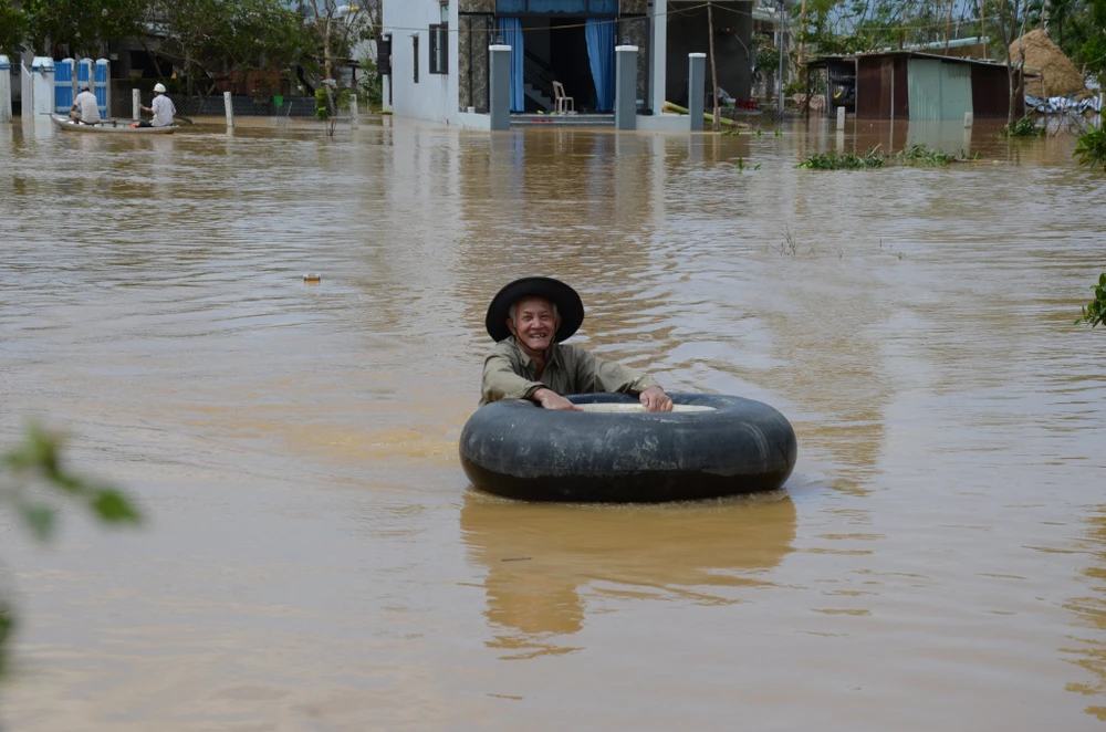 Một số người dân dùng phao bơi để vượt qua vùng nước lụt