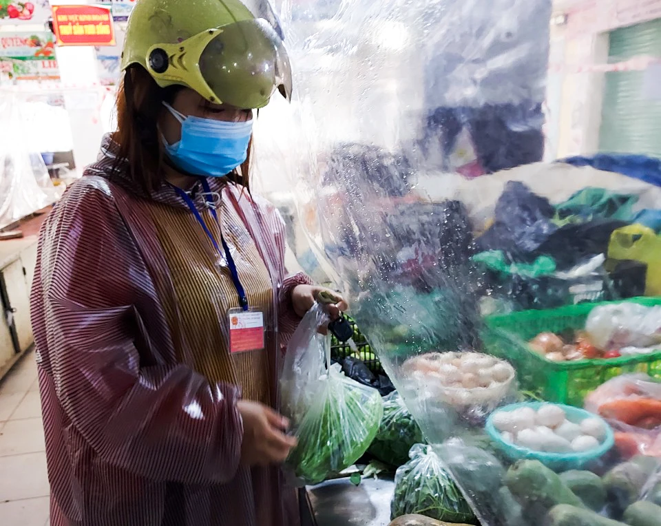Thành viên tổ đi chợ thuộc ban điều hành tổ dân phố 43, phường An Hải Bắc, quận Sơn Trà mặc áo mưa đi chợ truyền thống