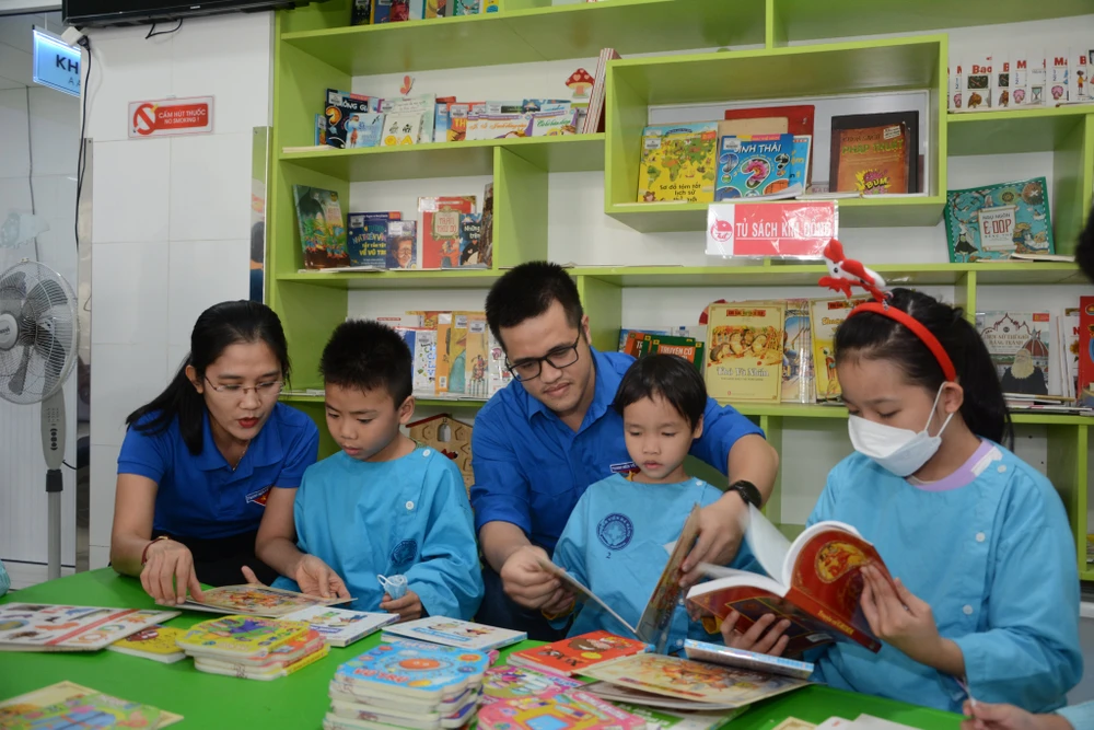 Các đoàn viên, thanh niên hướng dẫn các bệnh nhi cách đọc sách tại Bệnh viện Đà Nẵng