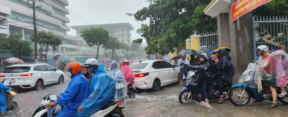 Học sinh Đà Nẵng vất vả về nhà trong thời tiết mưa lớn ngày 13-10. Ảnh: XUÂN QUỲNH