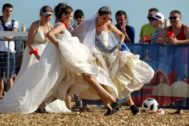 Tuy có phần vướng víu nhưng những chiếc váy cưới trắng chính là điểm nhấn khiến các cô gái thêm nổi bật tại khu vực Fan Fest. Ảnh: Reuters