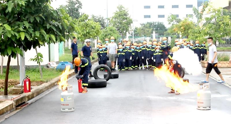 Các “lính cứu hỏa nhí” sử dụng bình chữa cháy dập tắt ngọn lửa phát ra từ bình gas