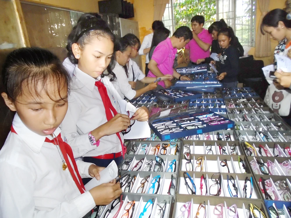 Các học sinh vùng sâu tỉnh Kiên Giang lựa kính do đoàn khám bệnh từ thiện của Hội Mắt kính TPHCM tặng