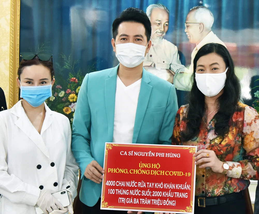Đại diện UBMTTQ VN tại TPHCM nhận bảng tượng trưng ủng hộ của ca sĩ Nguyễn Phi Hùng và Vy Oanh