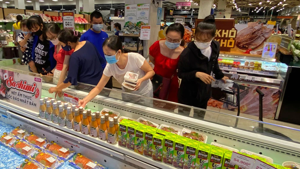 Người tiêu dùng mua thực phẩm khuyến mãi tại siêu thị Aeon Mall Bình Tân. Ảnh: CAO THĂNG