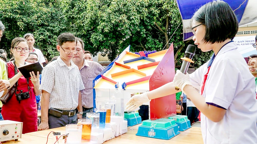 Học sinh Trường THCS Đồng Khởi giới thiệu thí nghiệm phản ứng hóa học theo dạng domino. Ảnh: HOÀNG HÙNG