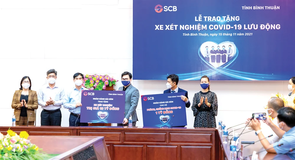 Ông Trương Khánh Hoàng - Q.TGĐ SCB trao bảng tượng trưng xe xét nghiệm Covid-19 lưu động có giá trị 15 tỷ đồng và 01 tỷ đồng cho Quỹ cứu trợ của UBMTTQ Việt Nam tỉnh Bình Thuận