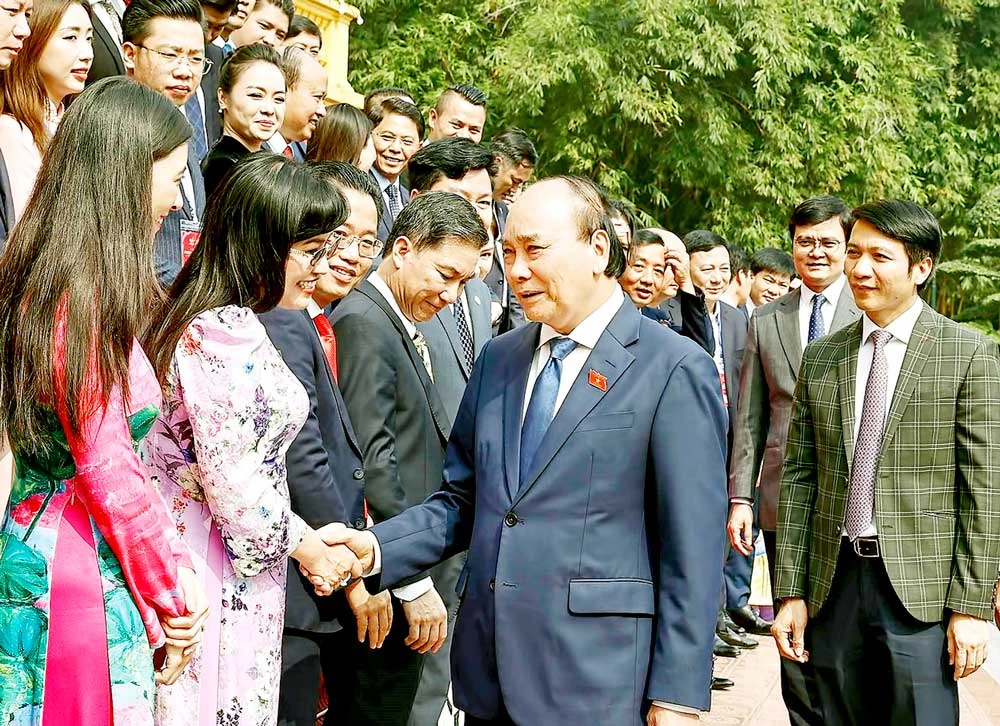 Chủ tịch nước Nguyễn Xuân Phúc với các doanh nhân trẻ. Ảnh: TTXVN