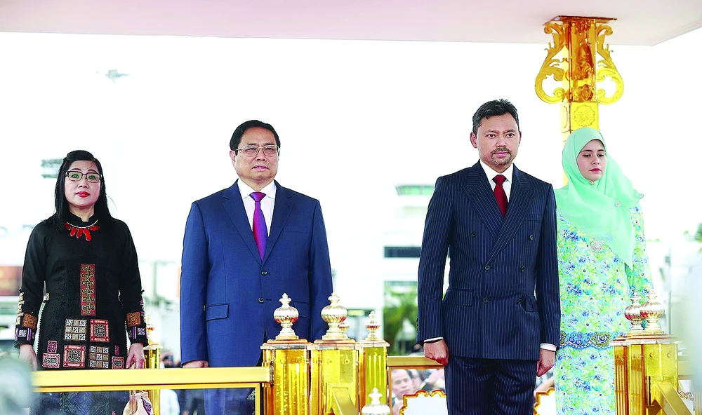 Thủ tướng Phạm Minh Chính cùng Thái tử kế vị Brunei Al-Muhtadee Billah trên bục danh dự, thực hiện nghi thức chào cờ. Ảnh: TTXVN