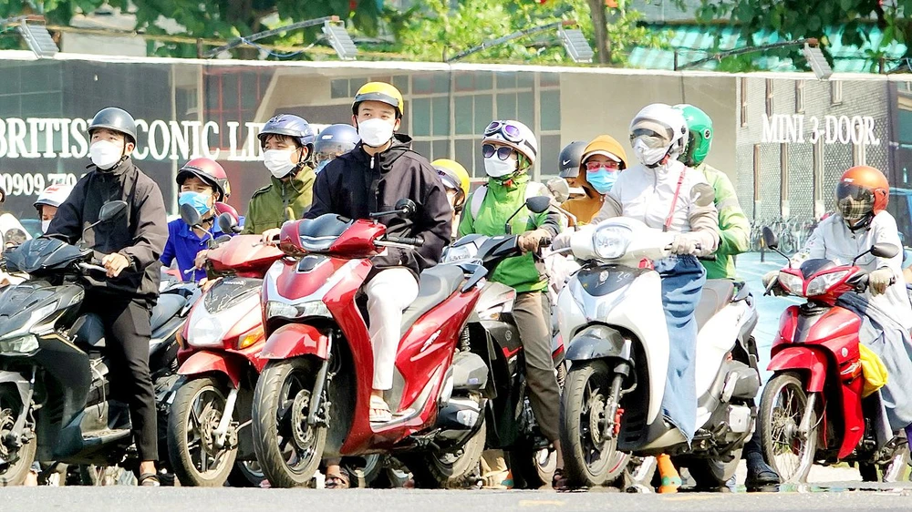 Người dân TP Đà Nẵng mặc áo khoác, trùm khẩu trang kín mặt để tránh nắng khi ra đường. Ảnh: XUÂN QUỲNH