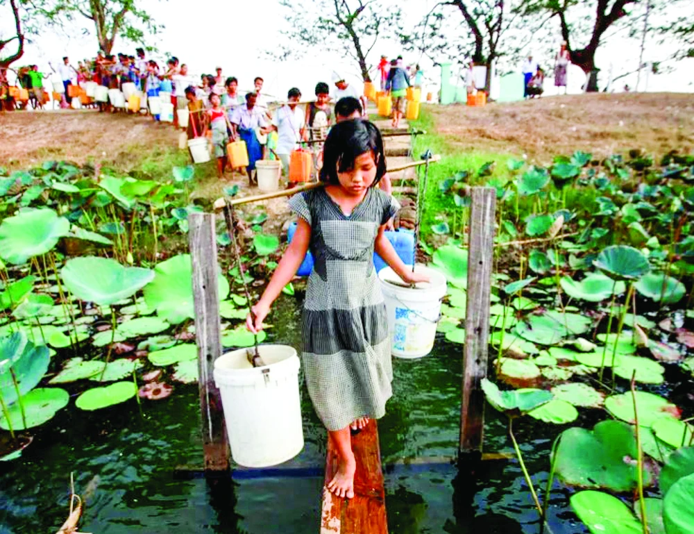 Người dân xếp hàng lấy nước tại hồ Yazarthingyan, gần Yangon, Myanmar. Ảnh: REUTERS 