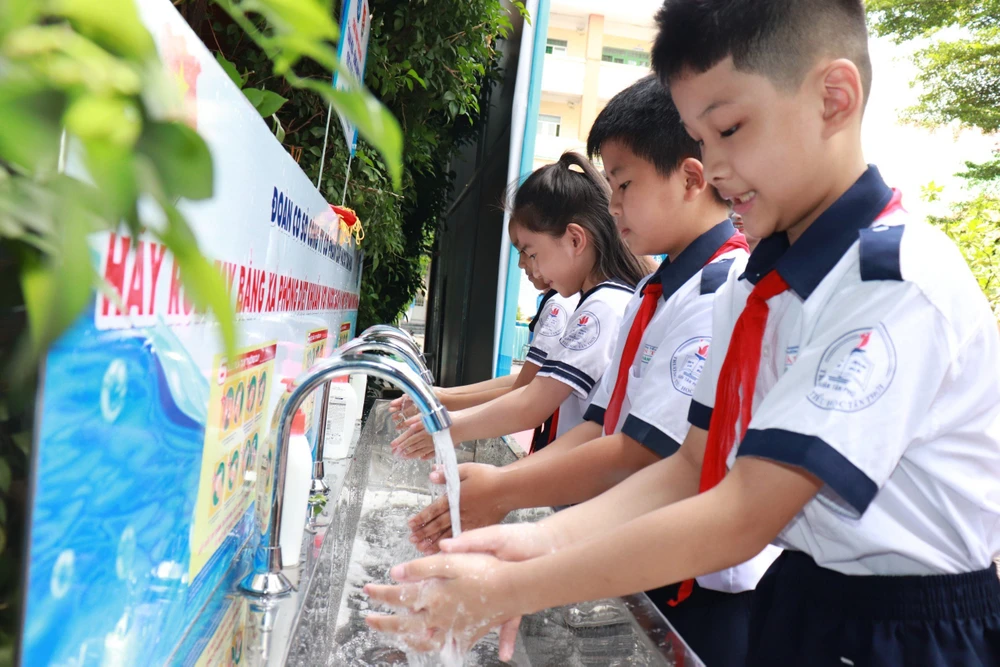 Niềm vui của các em học sinh khi được sử dụng nước sạch. Ảnh: ĐINH BÍCH