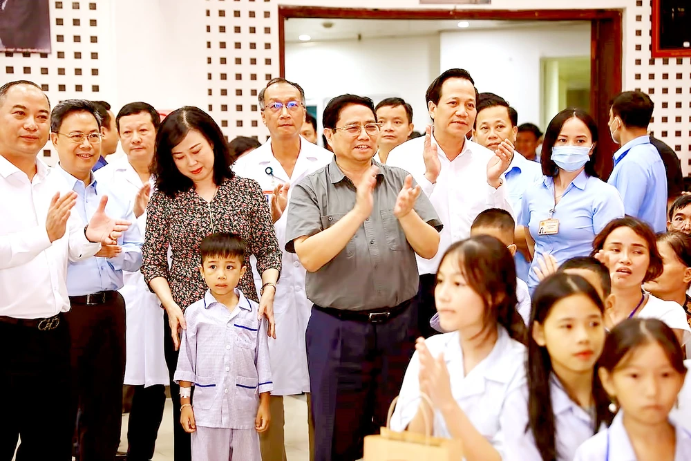 Thủ tướng Phạm Minh Chính và lãnh đạo các bộ, ngành thăm bệnh nhi đang điều trị tại Viện Huyết học và Truyền máu Trung ương. Ảnh: TTXVN