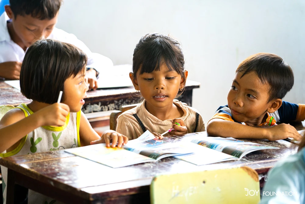 Các em nhỏ ở Đất Bằng (Krông Pa, Gia Lai) vui mừng trước món quà là những đầu sách mà JOY mang tới