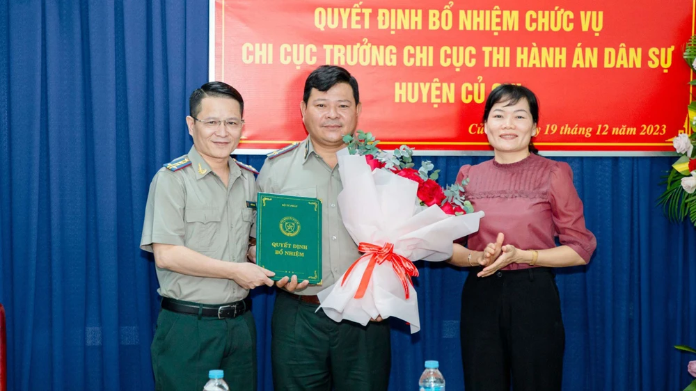 Cục trưởng Cục THADS TPHCM Nguyễn Văn Hòa cùng lãnh đạo huyện Củ Chi tặng hoa chúc mừng ông Phan Văn Phước. Ảnh: CẨM TÚ 