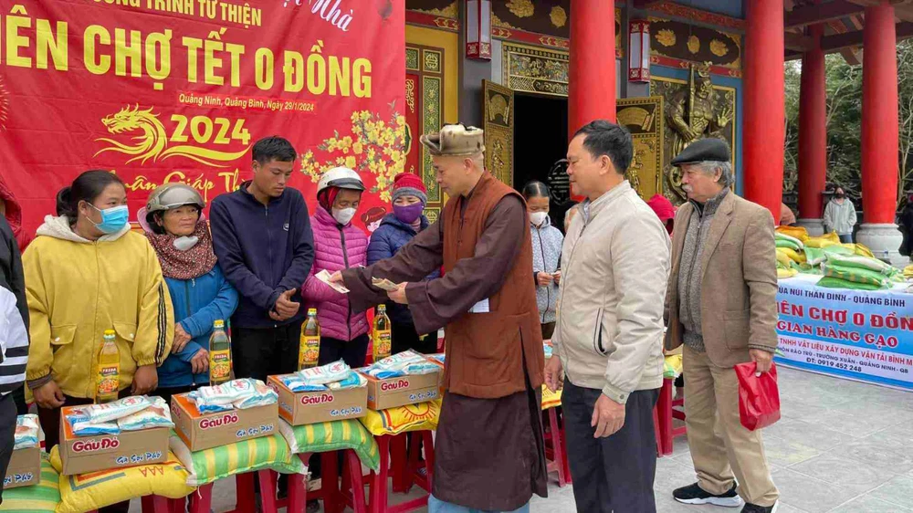 Thượng tọa Thích Trung Sơn, Phó Ban Từ thiện - Xã hội, Ban Trị sự Giáo hội Phật giáo Việt Nam TPHCM phát tiền đi chợ tết cho các hộ dân