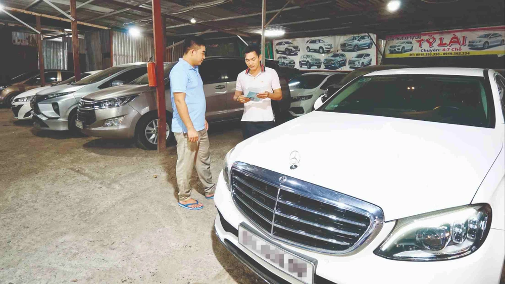 Nhân viên một công ty cho thuê xe tự lái trên đường Cao Lỗ, quận 8, TPHCM, giới thiệu mẫu xe cho khách đến thuê. Ảnh: HOÀNG HÙNG