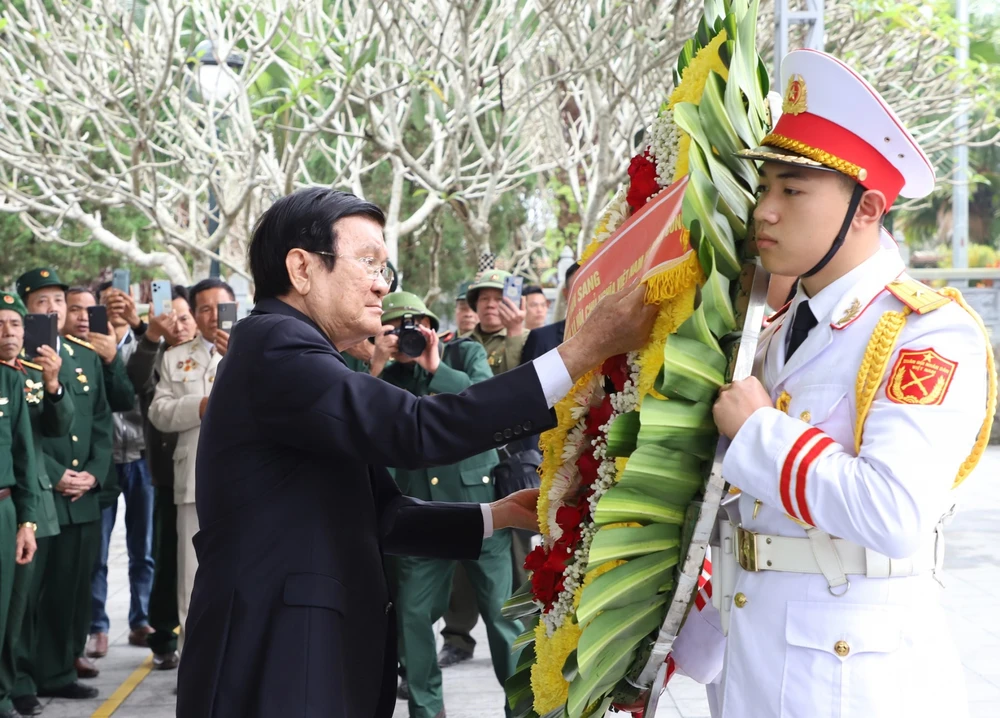 Nguyên Chủ tịch nước Trương Tấn Sang chỉnh vòng hoa trước khi dâng lên trước Tượng đài Tổ quốc ghi công tại Nghĩa trang Liệt sỹ quốc gia Vị Xuyên. Ảnh: VĂN NGHỊ
