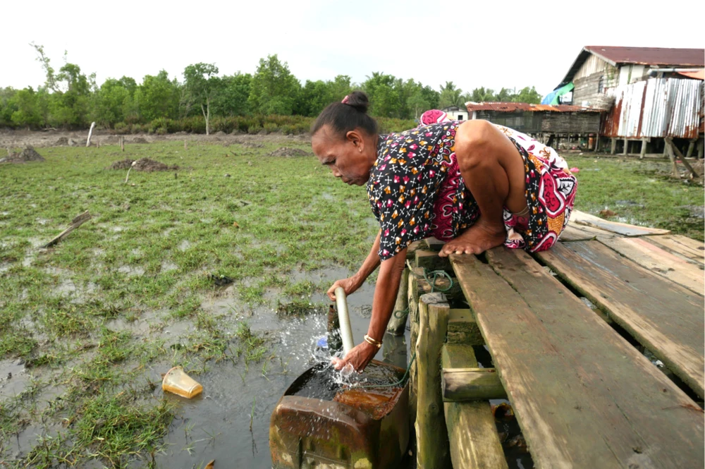 Người dân bơm nước ngầm lên để sử dụng tại làng Kuala Selat, Indragiri Hilir, Riau. Ảnh: JAKARTA POST