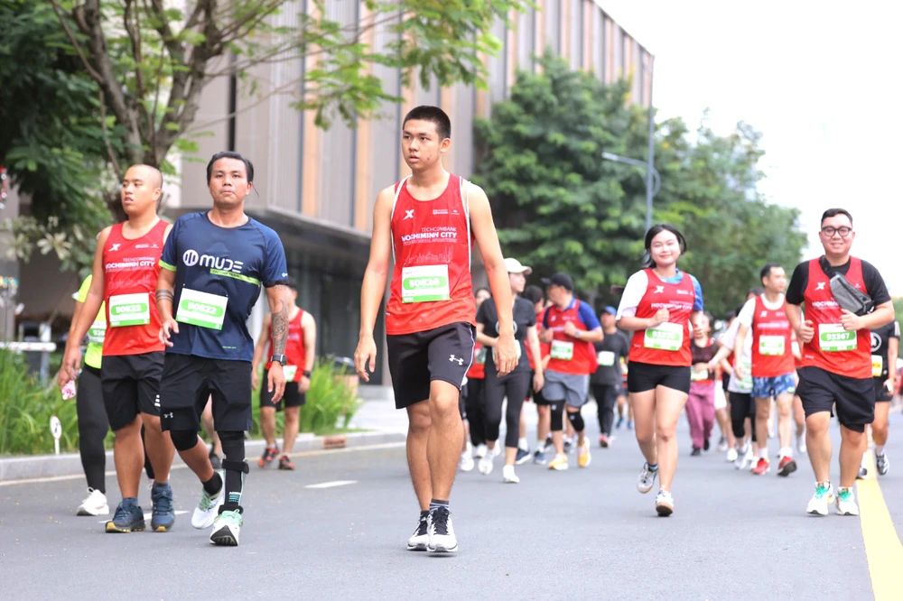 VĐV khuyết tật Võ Huỳnh Anh Khoa (thứ 2 từ trái qua) là gương mặt quen thuộc ở các giải chạy bộ tại TPHCM. Ảnh: P.MINH