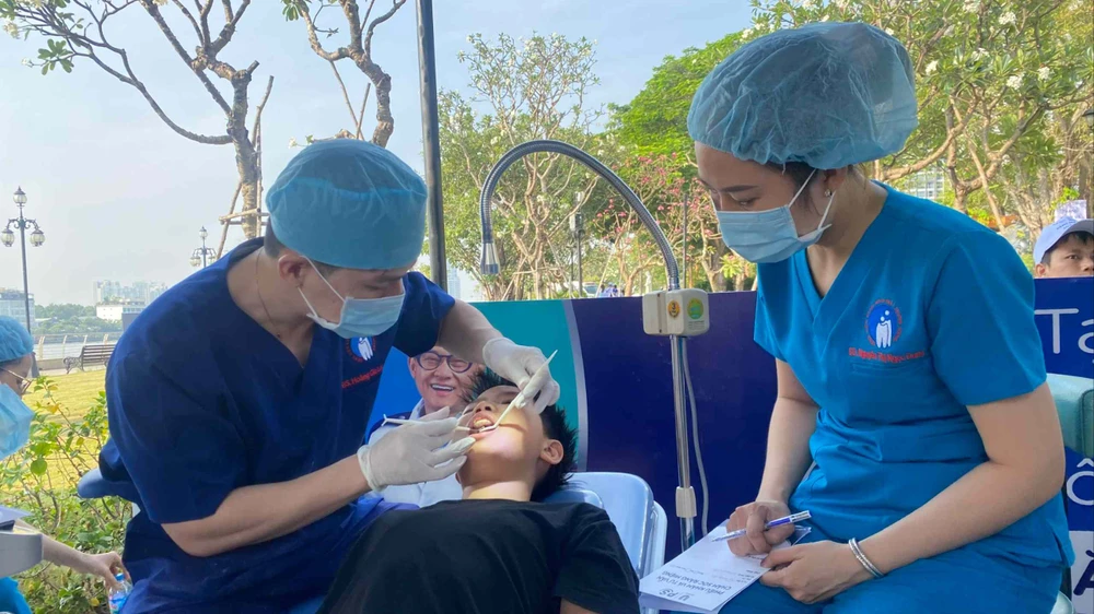 Bác sĩ Bệnh viện Răng Hàm Mặt Trung ương TPHCM đang thăm khám răng cho một học sinh