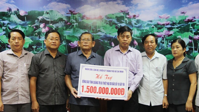 Đại diện đoàn lãnh đạo TPHCM trao số tiền hỗ trợ tỉnh Quảng Trị. Ảnh: HOÀI NAM