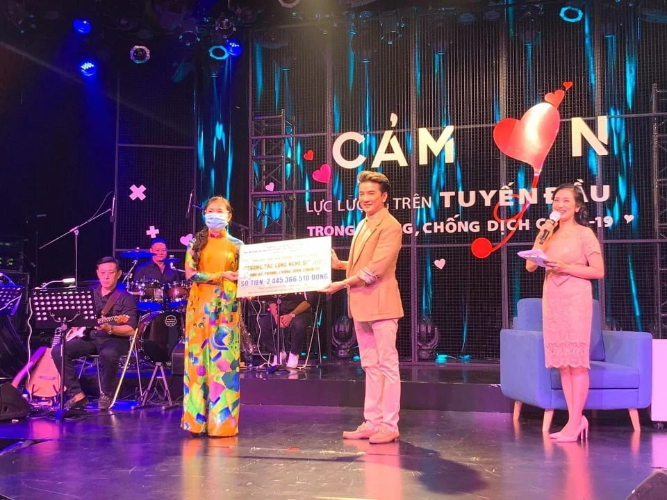 Ca sĩ Đàm Vĩnh Hưng (phải) trao số tiền hơn 2 tỷ đồng vận động đóng góp từ chương trình "Tương tác cùng nghệ sĩ" ủng hộ phòng, chống dịch Covid-19