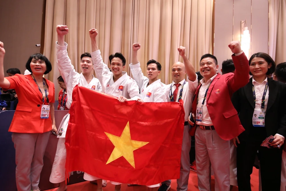 Phó Tổng cục trưởng Tổng cục TDTT Lê Thị Hoàng Yến (bìa trái) chúc mừng đội tuyển nam kata Việt Nam. ẢNH: DŨNG PHƯƠNG