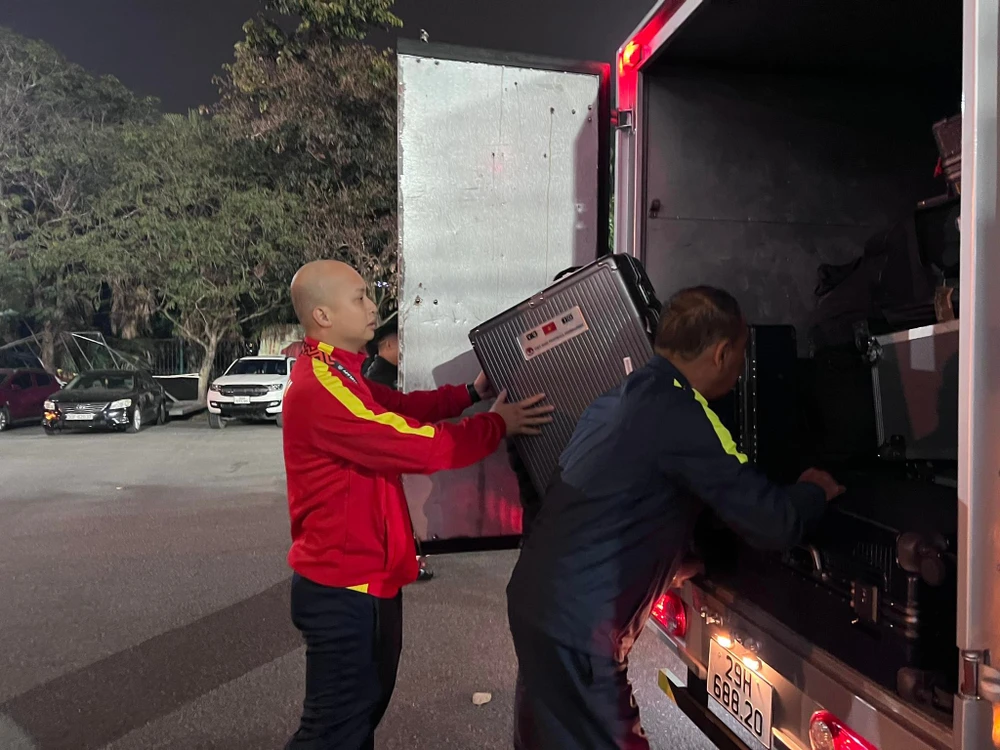 Một thành viên của đội tuyển Việt Nam đưa vali của các thành viên lên xe tải. ẢNH: HỮU THÀNH 
