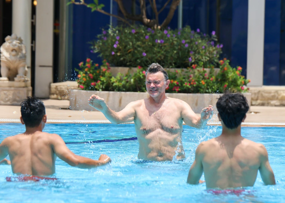 HLV Philippe Troussier khoe cơ bụng cùng các tuyển thủ U22 Việt Nam ở hồ bơi. 