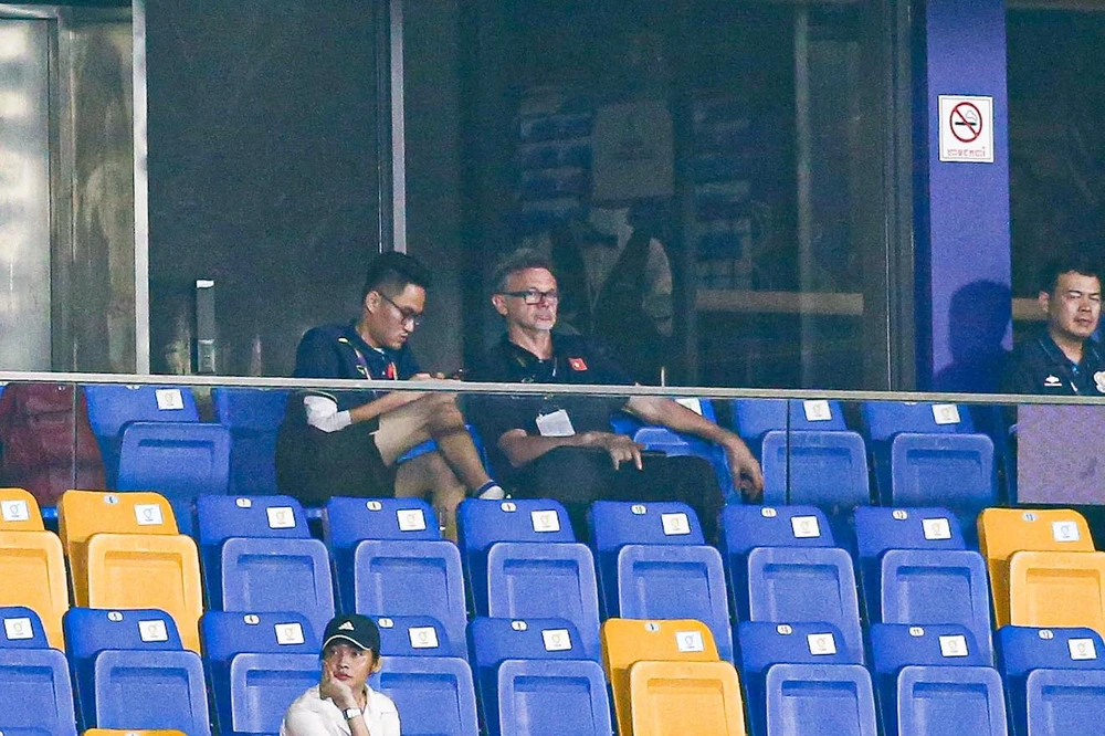 HLV Philippe Troussier cùng phiên dịch viên Hoàng Xuân Bách dự khán trận U22 Malaysia - U22 Lào. ẢNH: TÂM HÀ 