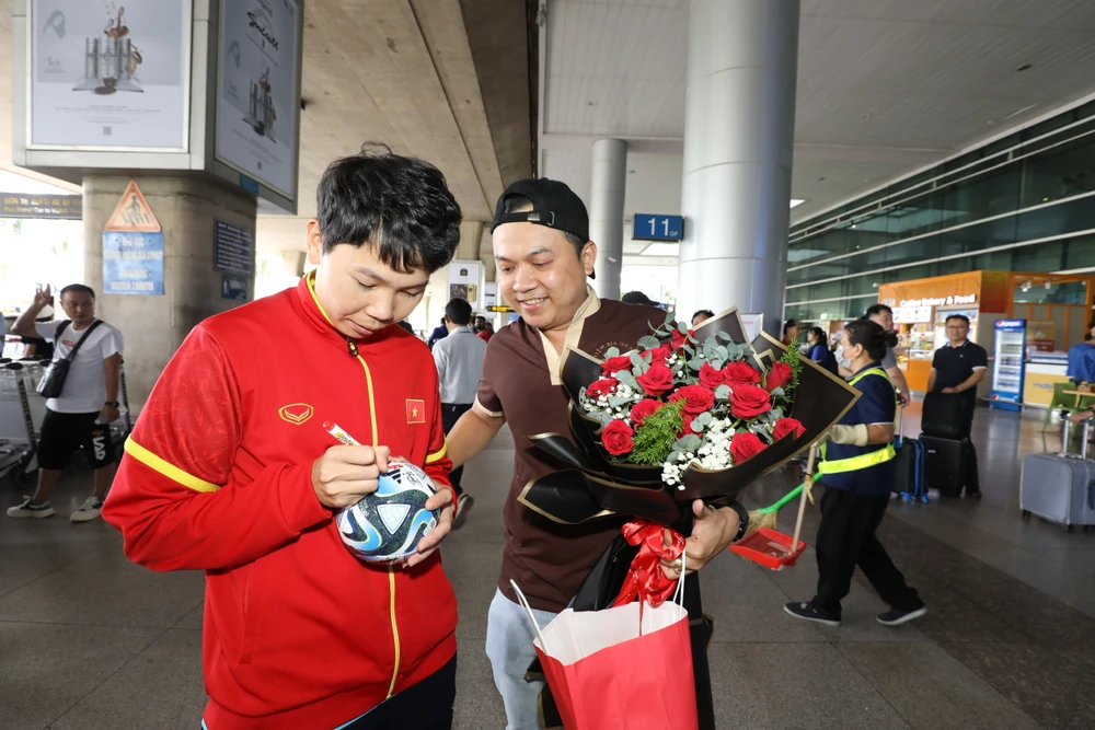 Thủ môn Trần Thị Kim Thanh ký tặng cho một cổ động viên ở sân bay. ẢNH: DŨNG PHƯƠNG 