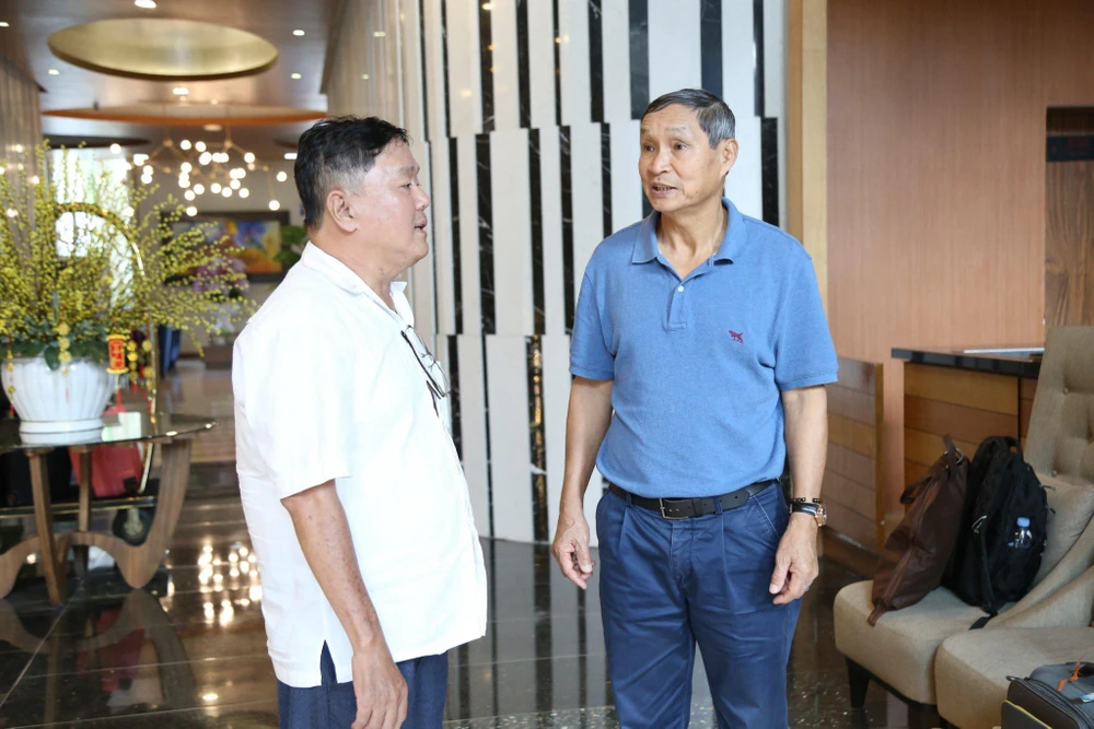 Ông Mai Đức Chung (phải) trò chuyện với thành viên Ban tổ chức Giải thưởng Quả bóng vàng Việt Nam 2023. ẢNH: TIÊU HẰNG 