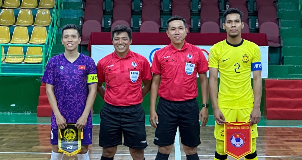 Trọng tài Trương Quốc Dũng (áo đỏ, bên trái) làm nhiệm vụ ở trận giao hữu giữa hai đội tuyển futsal Việt Nam và Malaysia mới đây. ẢNH: FAM 