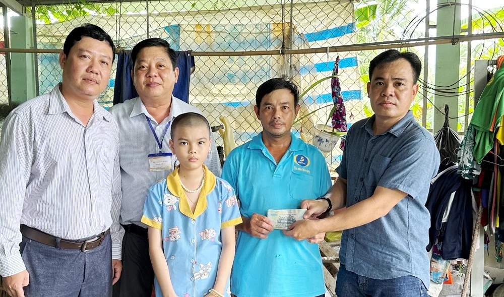 Đại diện Báo SGGP phối hợp cùng chính quyền địa phương trao hỗ trợ 17 triệu đồng giúp bé Ngọc Ánh có tiền chữa bệnh