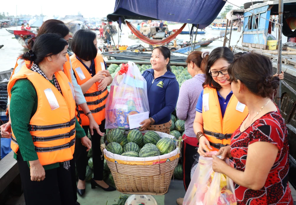 Tiểu thương vui mừng được nhận quà tết khi đang bán trên sông nước chợ nổi Cái Răng. Ảnh: PHẠM TRUNG