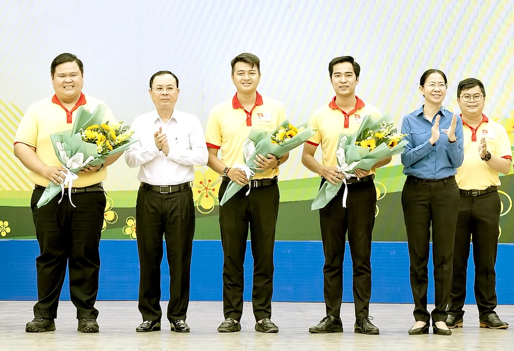 Phó Bí thư Thành ủy TPHCM Nguyễn Văn Hiếu trao hoa cho đội hình ra quân Chiến dịch Xuân tình nguyện 2022. Ảnh: QUỐC THANH