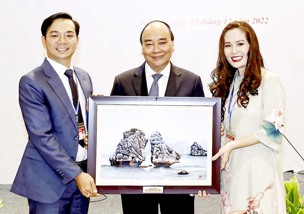 Chủ tịch nước Nguyễn Xuân Phúc tặng quà lưu niệm cho đại diện cộng đồng người Việt Nam tại Indonesia. Ảnh: TTXVN