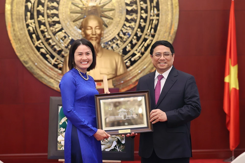 Thủ tướng Phạm Minh Chính tặng quà cho đại diện cộng đồng người Việt Nam tại Trung Quốc. Ảnh: TTXVN