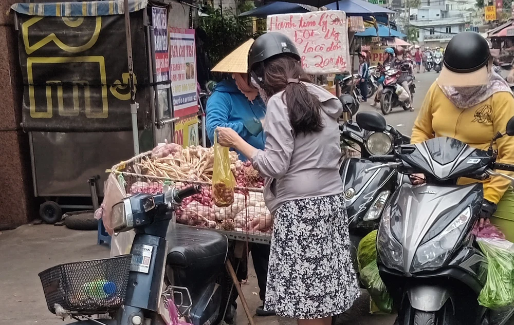 Một người dân tại TPHCM sử dụng túi ni lông đựng đồ khi mua hàng