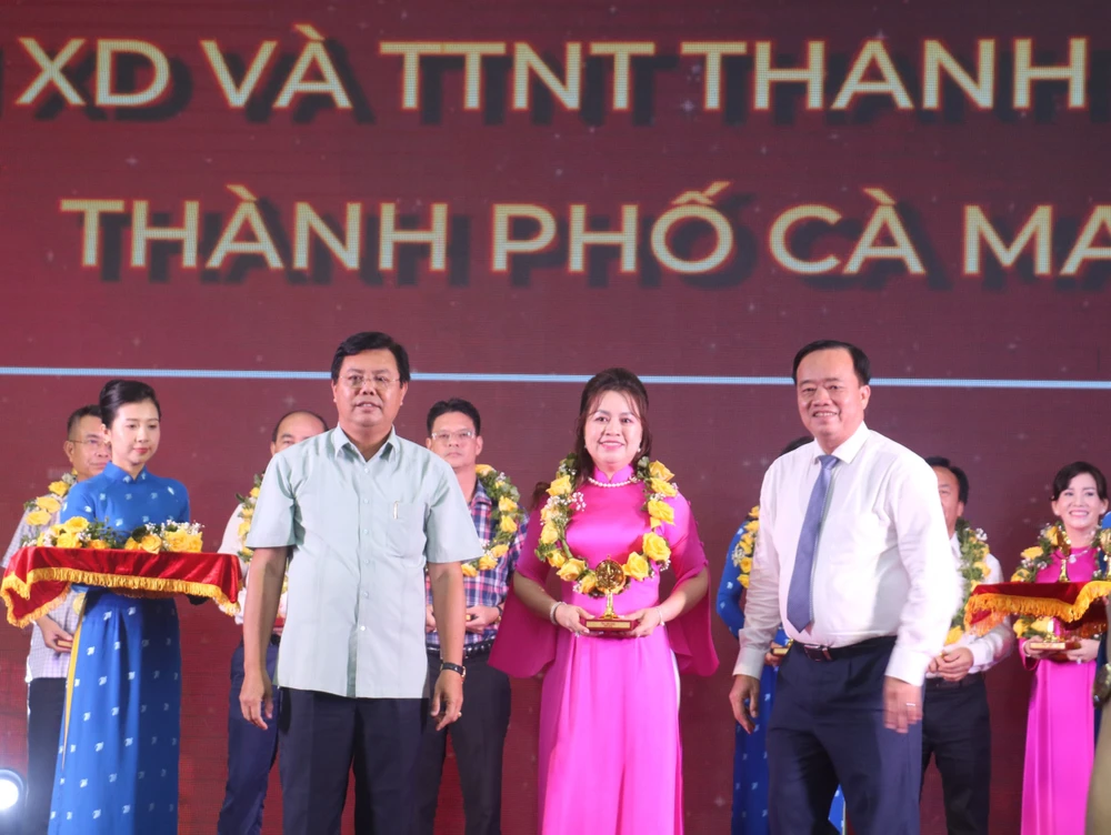 Bí thư Tỉnh ủy Cà Mau Nguyễn Tiến Hải (trái) và Chủ tịch UBND tỉnh Huỳnh Quốc Việt (phải) trao biểu trưng và hoa cho doanh nghiệp tiêu biểu tỉnh Cà Mau năm 2023