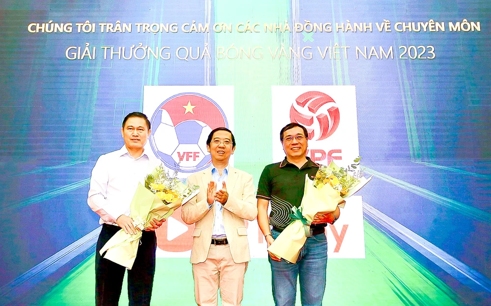 Nhà báo Nguyễn Nhật, Trưởng Ban Tổ chức giải thưởng, tặng hoa đại diện nhà đồng hành về chuyên môn - VFF và FPT Play. Ảnh: DŨNG PHƯƠNG