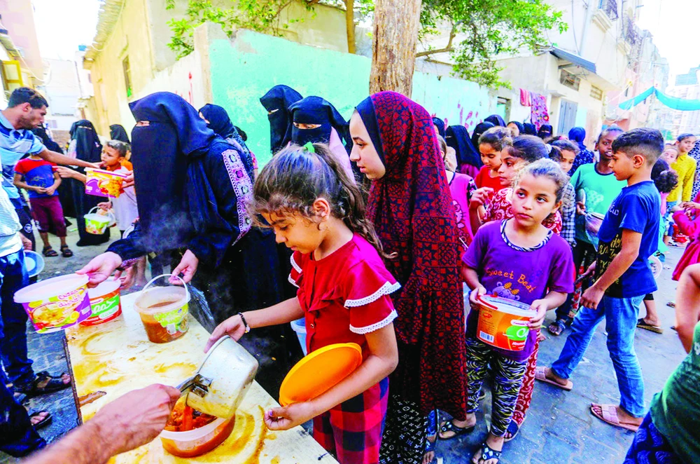 Người dân tại Dải Gaza nhận thức ăn cứu trợ. Ảnh: AP