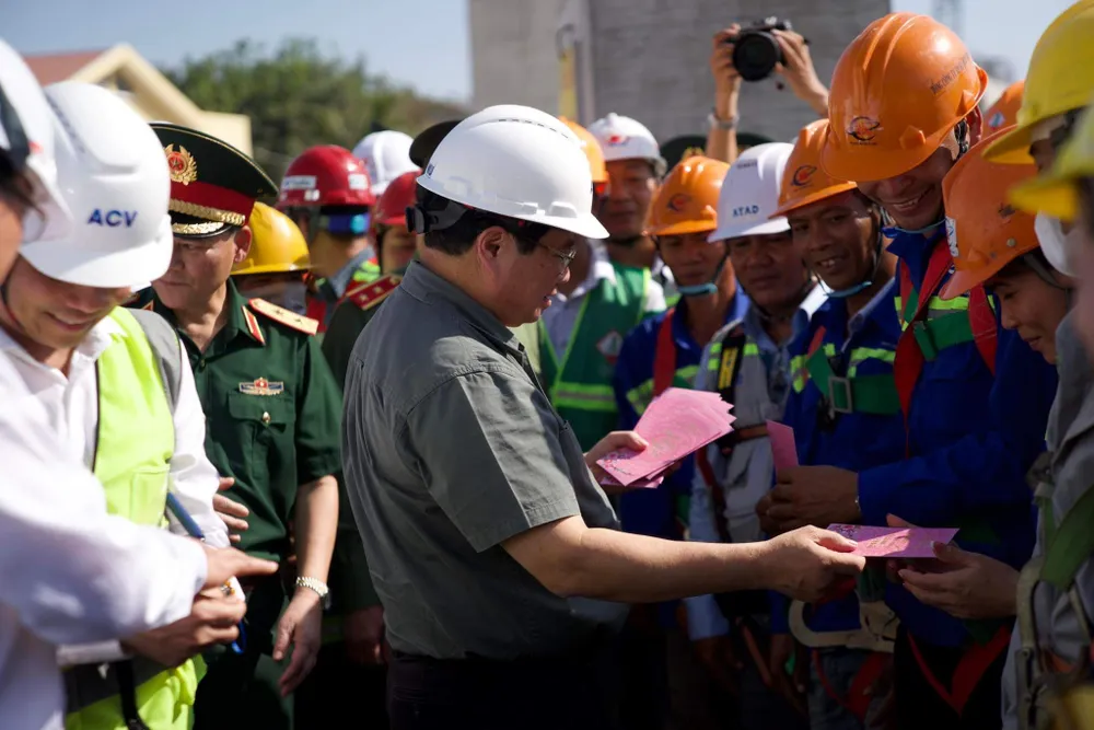 Thủ tướng Phạm Minh Chính lì xì đầu năm cho công nhân đang làm việc trên công trường thi công Dự án Nhà ga T3. Ảnh: HOÀNG HÙNG img-6137-6910.jpg