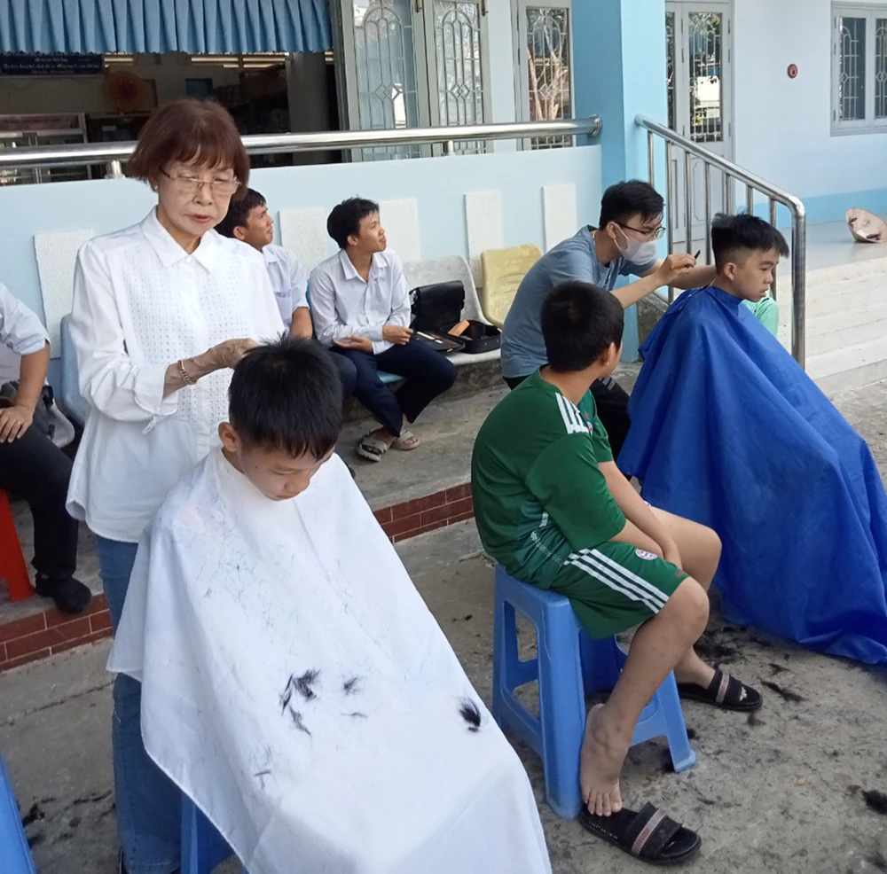 Bà Trần Thị Ánh cắt tóc cho học sinh Trường Nuôi dạy trẻ khuyết tật tỉnh Đồng Tháp