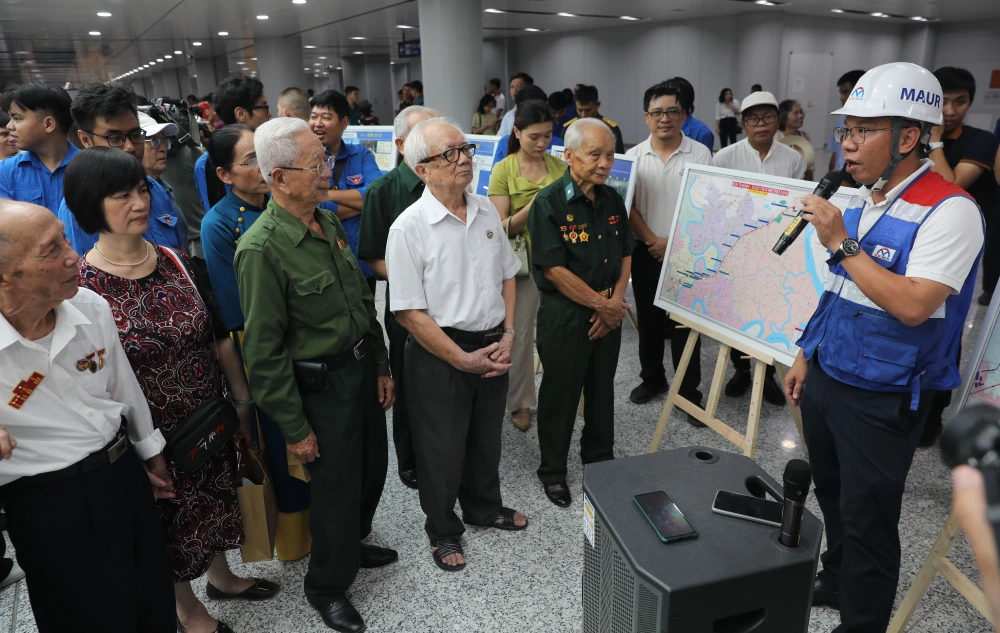 Nhân viên Ban Quản lý đường sắt đô thị TPHCM giới thiệu dự án metro số 1 đến các cựu binh Điện Biên Phủ và đại biểu tham gia buổi chạy thử nghiệm metro. Ảnh: DŨNG PHƯƠNG